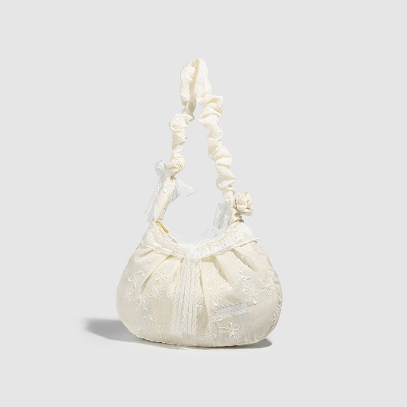 Elfenbeinfarbene, halbmondförmige Schultertasche mit Blumenstickerei, Spitzenbesatz und gerafftem Rüschenstoffriemen mit Schleifendetail, Detailansicht