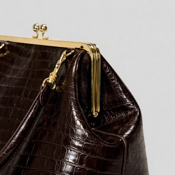 Trapezoid kiss-lock frame shoulder bag with gold-tone hardware and slim adjustable strap, detail view 14