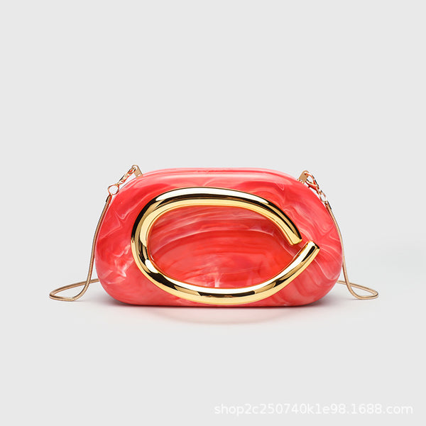 Kleine rechteckige Crossbody-Clutch mit abgerundeten Ecken, oversized poliertem C-förmigem Goldgriff und schmalem Goldkettenriemen, Detailansicht