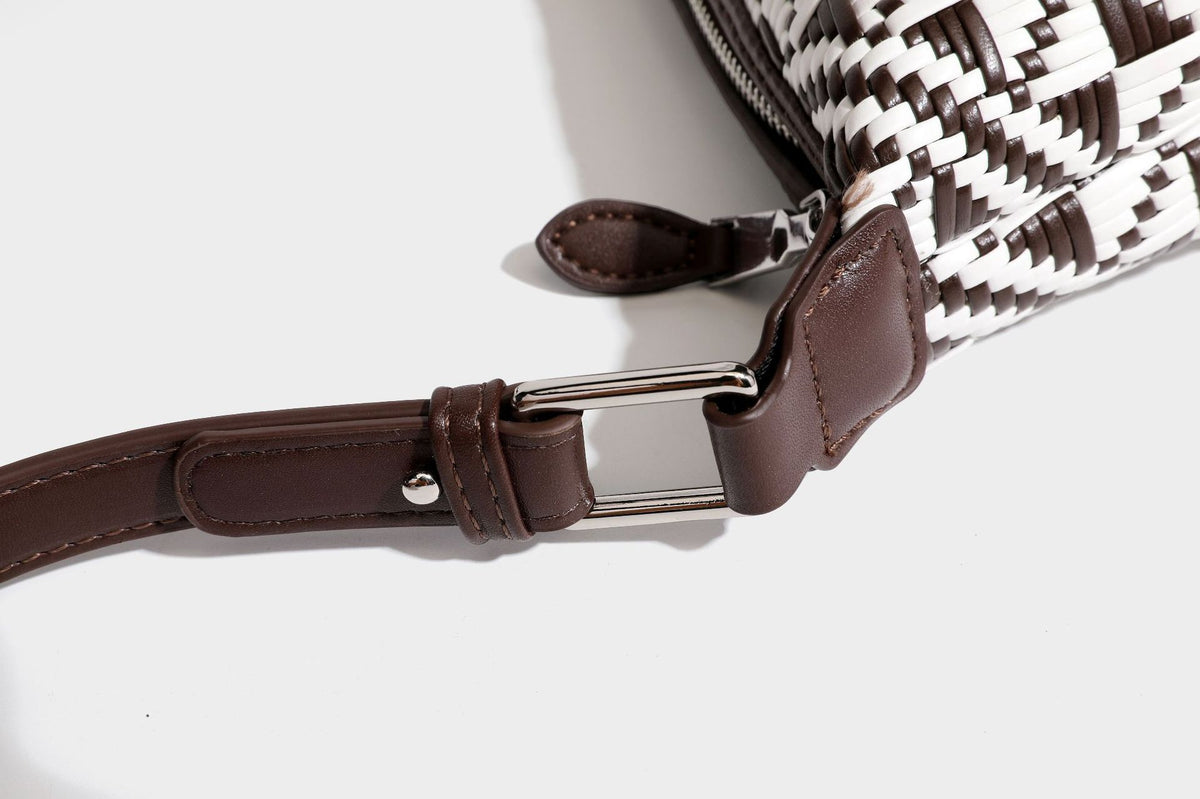 Kleine schwarz-weiße Schultertasche mit gewebtem geometrischem Muster, glatter dunkelbrauner Besatz aus Lederoptik, geknotetem verstellbarem Riemen und seitlichem