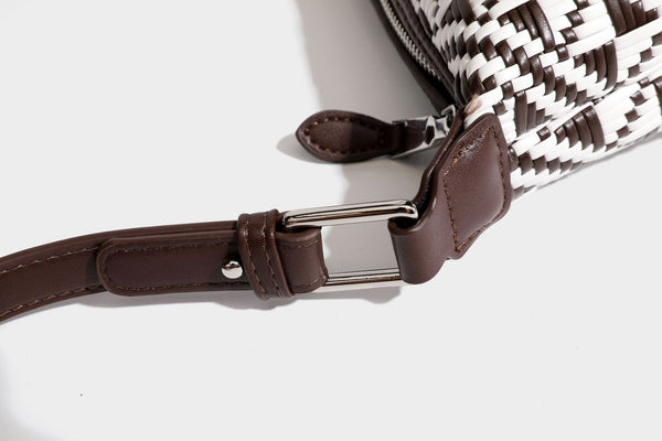 Kleine schwarz-weiße Schultertasche mit gewebtem geometrischem Muster, glatter dunkelbrauner Besatz aus Lederoptik, geknotetem verstellbarem Riemen und seitlichem