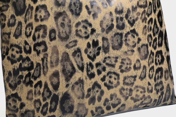 Large leopard print shoulder tote bag in tan and brown with slim dark straps and dangling beaded charm hardware, detail view