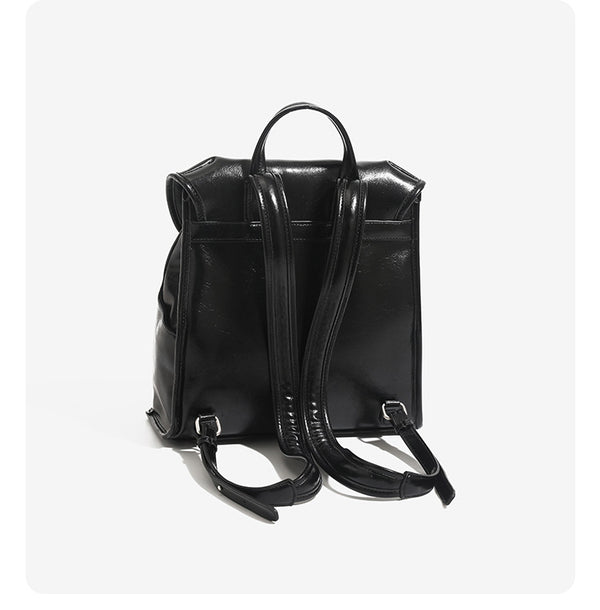 Structured glossy leather-look flap backpack handbag with dual buckle closures, top handle, and silver-tone hardware, detail