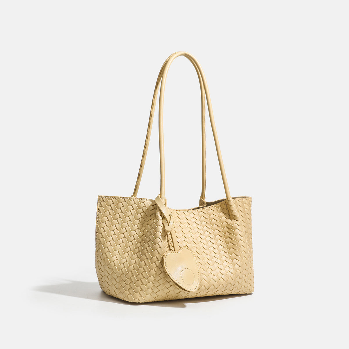 Woven leather-look tote bag in yellow with long shoulder straps, heart-shaped hanging charm, and removable inner zip pouch