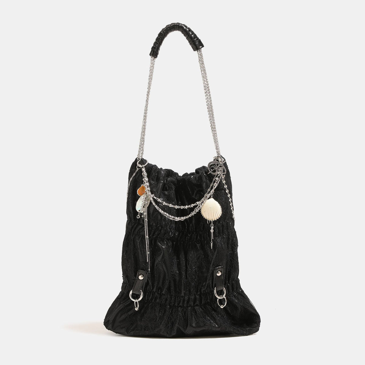 Slouchy lace-overlay bucket bag with silver chain strap, draped chain detail, shell charms, and drawstring top closure