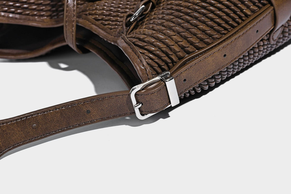 Große Schultertasche in Beutelform mit Flechtoptik, glatten Besätzen in Lederoptik, verstellbarem Riemen und hängendem Anhänger-Detail, Detailansicht