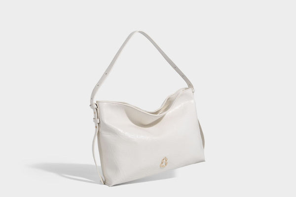 Large slouchy hobo shoulder bag in glossy crinkle leather-look finish with gold-tone emblem hardware and adjustable strap