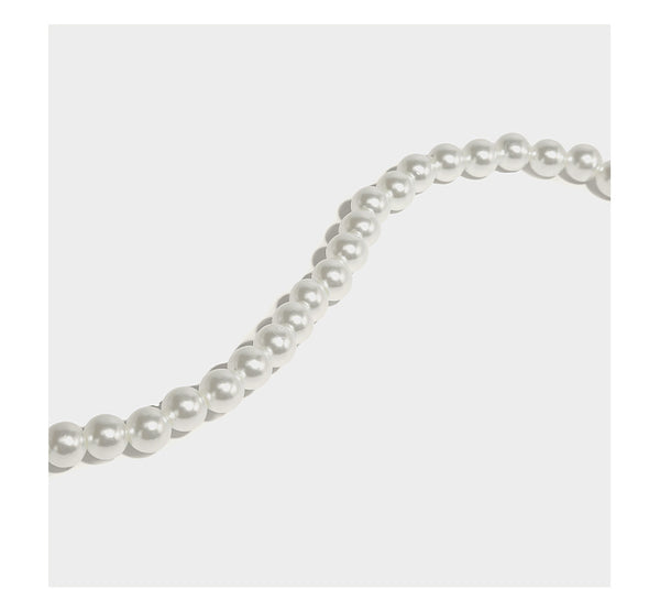 Small boxy pearl-bead mini top-handle bag with silver metallic bead accents, satin floral detail, and long beaded shoulder