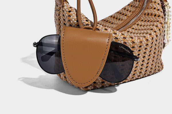 Woven crescent shoulder bag with leather-look knotted handle, zip top, attached mini pouch, and silver-tone hardware, detail