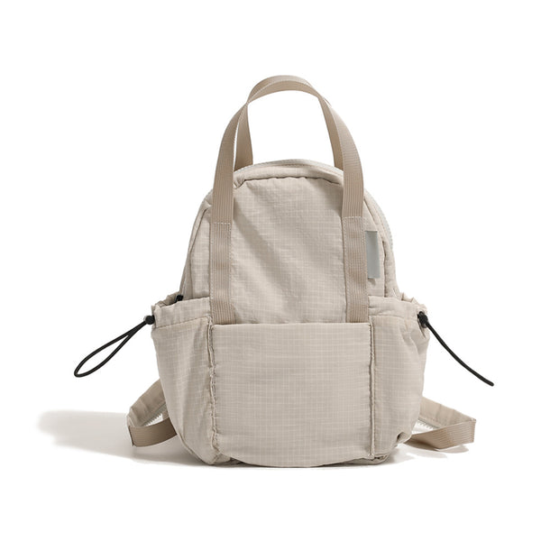 Small rounded mini backpack handbag in matte ripstop-texture fabric with top webbing handle, front pocket, side drawstring
