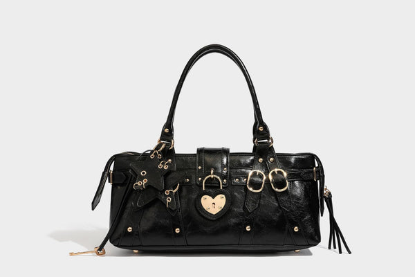 Glossy dark brown structured Boston satchel with heart-shaped lock charm, star pendant, rivet studs, multi-strap front panel