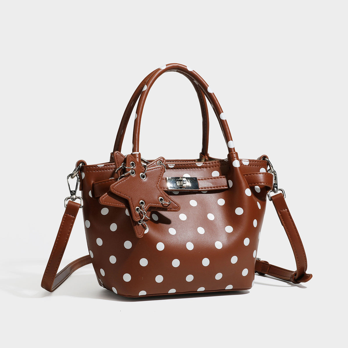 Small structured polka-dot mini tote bag in brown with white dots, star charm, dual top handles, and detachable shoulder