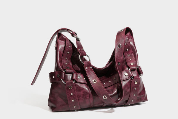 Lässige Hobo-Schultertasche in glänzender Lederoptik mit silberfarbenen Nieten, Riemendetail mit Schnalle und Reißverschluss oben