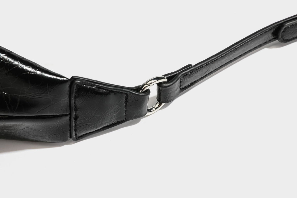 Legere, halbmondförmige Hobo-Schultertasche in glänzender, geknautschter Lederoptik mit schmalem Riemen, Ringbeschlägen in Silberoptik und