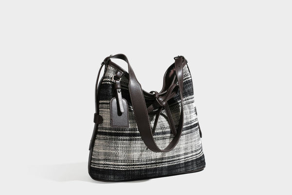 Schwarz-weiß karierte Hobo-Schultertasche aus gewebtem Material mit dunkelbrauner Einfassung in Lederoptik, Kordelzugverschluss und langem, verstellbarem