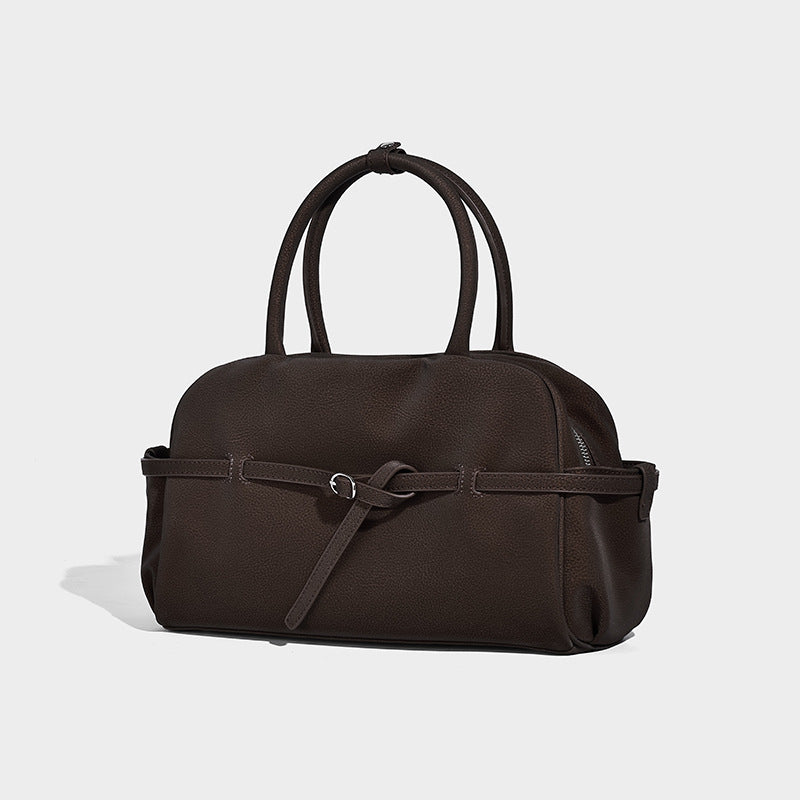 Strukturierte Henkeltasche mit matter, genarbter Oberfläche, umlaufendem Riemen mit Ringbeschlägen, zwei Tragegriffen und abnehmbarem Umhängeriemen
