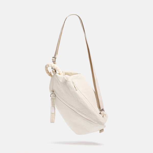Lässige Crossbody-Bag aus weichem Stoff mit geflochtenem Kordel-Tragegriff, diagonalem Reißverschlussfach auf der Vorderseite und silberfarbenen Details, Detailansicht