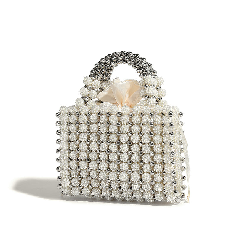 Small boxy pearl-bead mini top-handle bag with silver metallic bead accents, satin floral detail, and long beaded shoulder