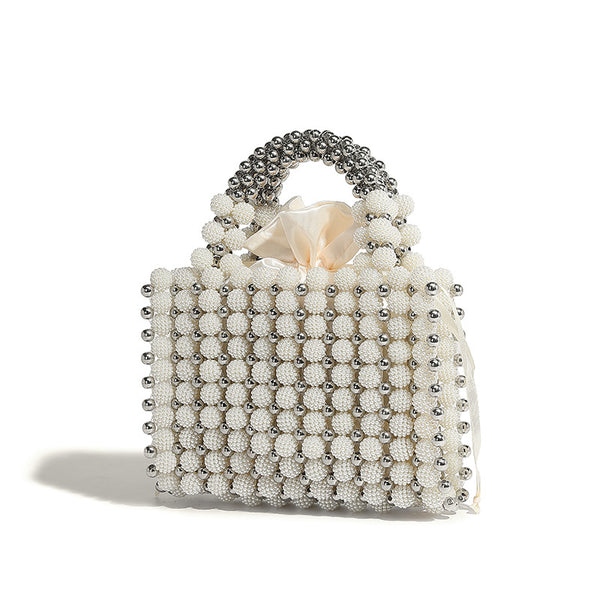 Small boxy pearl-bead mini top-handle bag with silver metallic bead accents, satin floral detail, and long beaded shoulder
