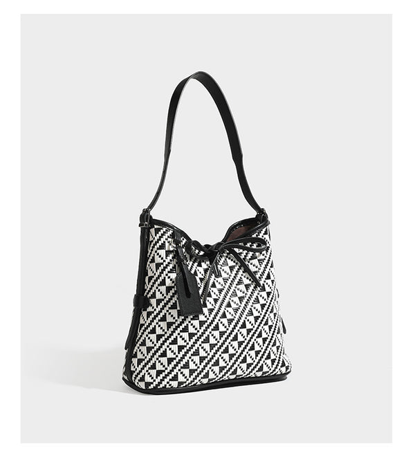 Woven geometric bucket shoulder bag in white and dark brown two-tone pattern with leather-look trim and drawstring top