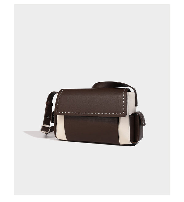 Structured flap crossbody bag in dark brown and cream color-block with white contrast stitching, adjustable shoulder strap