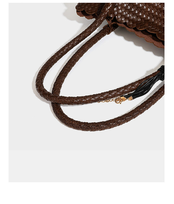 Strukturierter, glänzend geflochtener Shopper mit Muschelkantenabschluss am oberen Rand, geflochtenen Tragegriffen, abnehmbarem Crossbody-Riemen und Perlenquaste