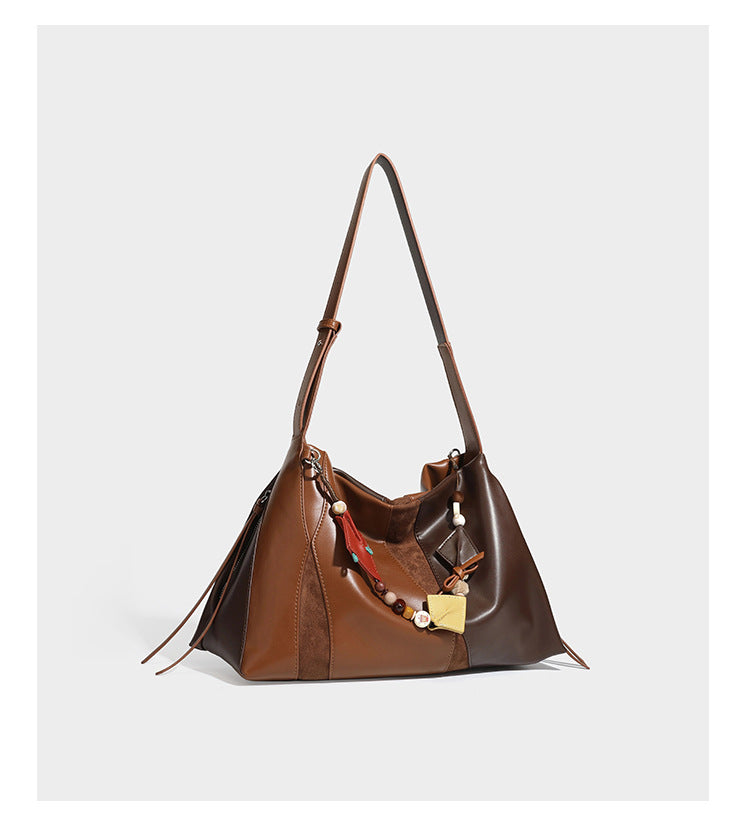 Two-tone black and brown leather-look slouchy shoulder bag with beaded tassel charm and silver-tone hardware, detail view 14