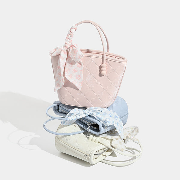 Quilted leather-look mini tote bag with printed scarf bow on braided top handle and silver-tone hardware, detail view 2