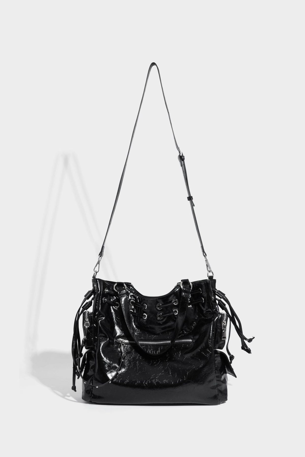 Glossy crinkled leather-look tote bag with silver grommet lace-up front detail, dual top handles, and detachable shoulder