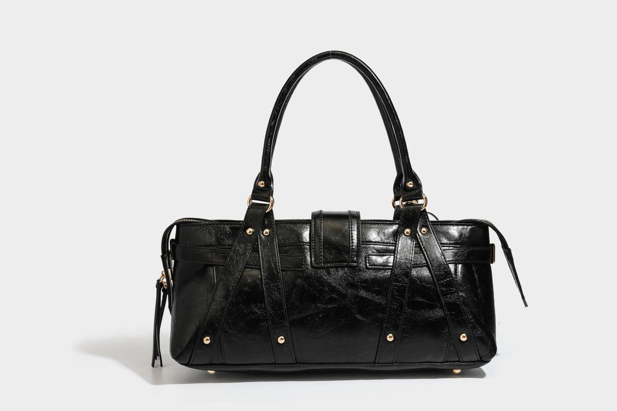 Glossy dark brown structured Boston satchel with heart-shaped lock charm, star pendant, rivet studs, multi-strap front panel