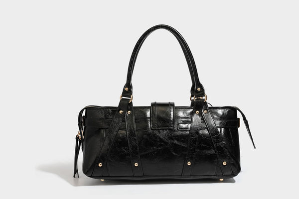 Glossy dark brown structured Boston satchel with heart-shaped lock charm, star pendant, rivet studs, multi-strap front panel