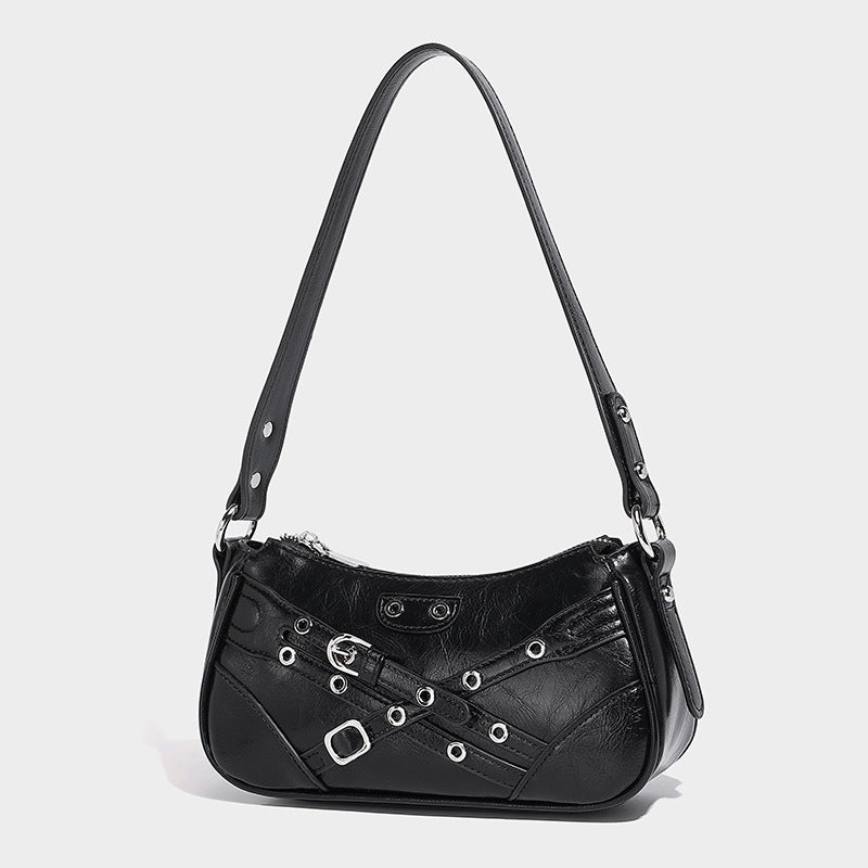 Compact moto-inspired shoulder bag with crisscross grommet strap detail, glossy textured finish, and adjustable crossbody