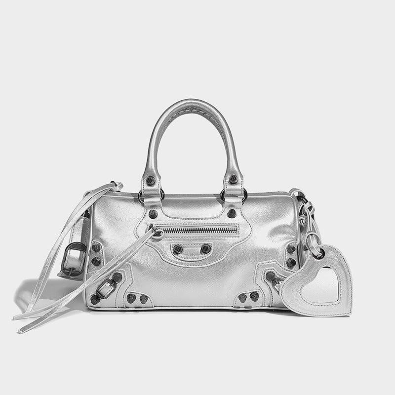 Glossy studded mini satchel bag with braided top handles, front zip pocket, heart charm, and detachable crossbody strap