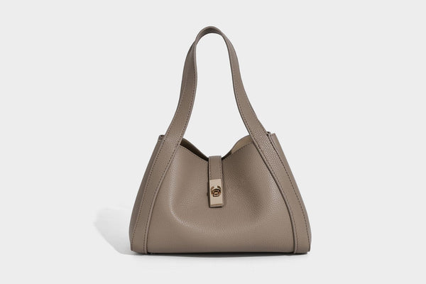 Structured trapezoid tote bag in taupe pebbled leather-look finish with gold-tone turn-lock hardware, dual top handles, and