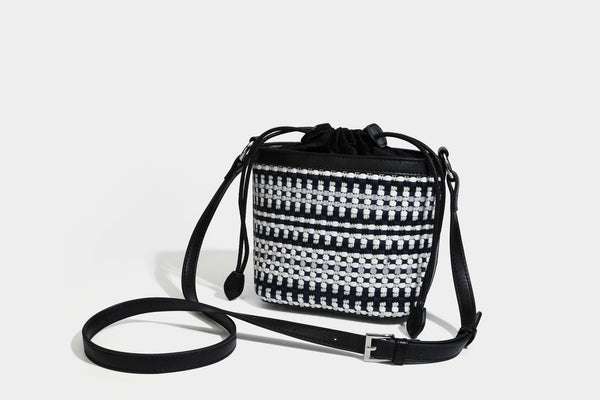 Small structured woven checker bucket bag with braided top handle, drawstring closure, and silver-tone hardware in black