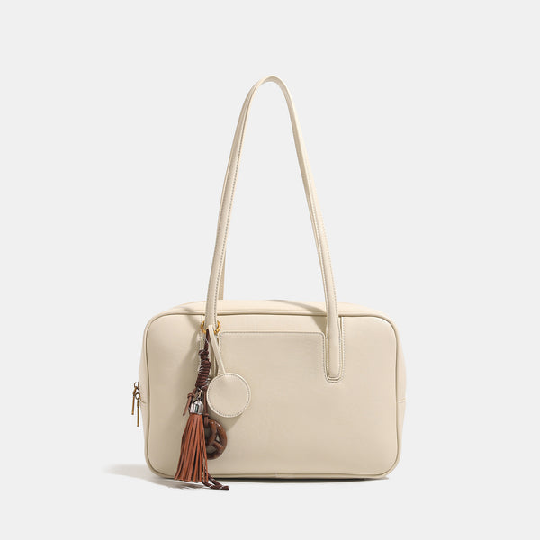 Structured rectangular leather-look shoulder bag with top zip, tassel and resin ring charm, and contrast topstitching, detail