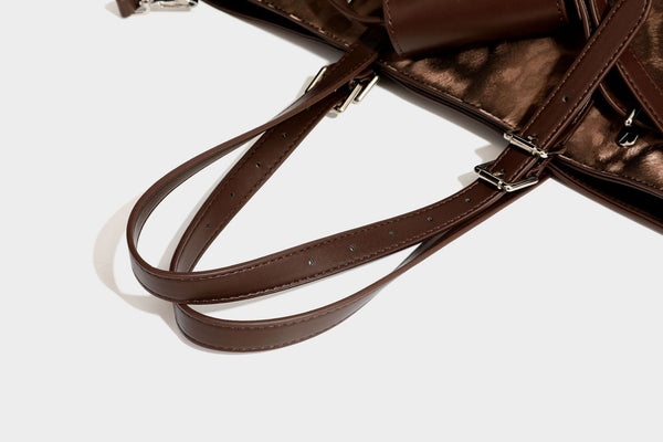 Glossy leopard-print tote bag with leather-look dark trim, dual top handles, detachable shoulder strap, and attached front