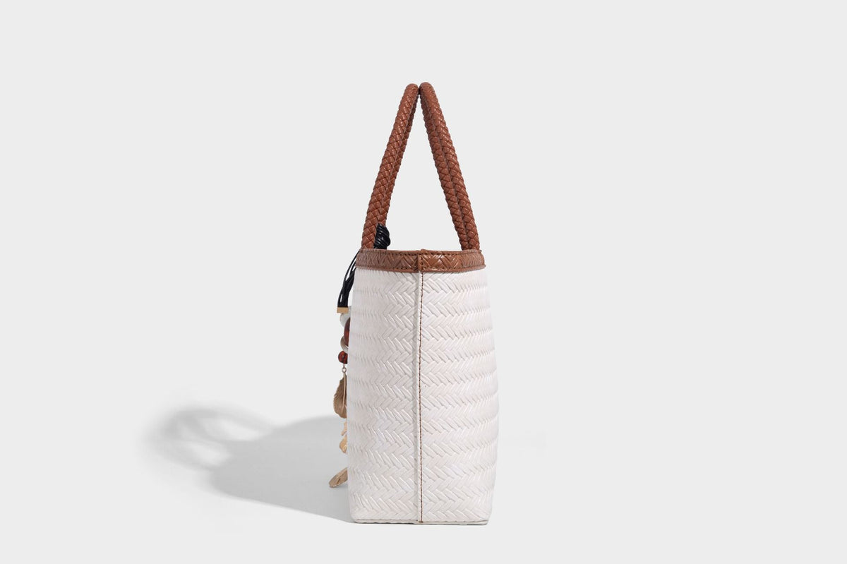 Structured woven-texture tote bag with brown braided top handles, decorative tassel charm, and detachable shoulder strap