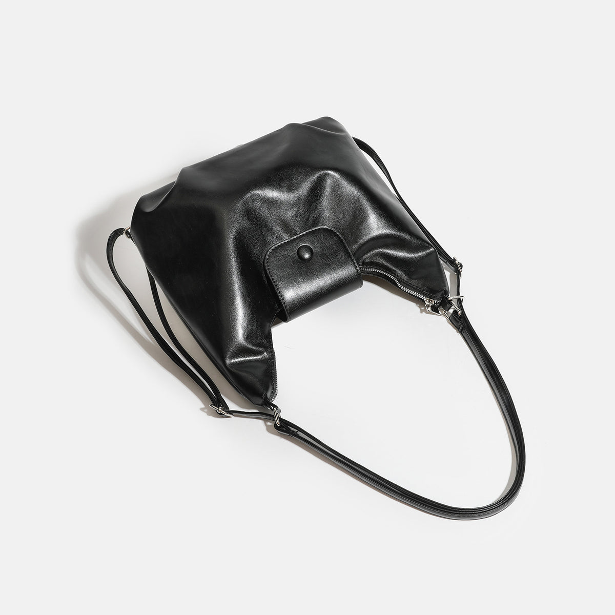 Lässig fallende Hobo-Schultertasche in glänzender Lederoptik mit vorderer Klappentasche und Druckknopf sowie silberfarbenen Metallbeschlägen, Detailansicht 4