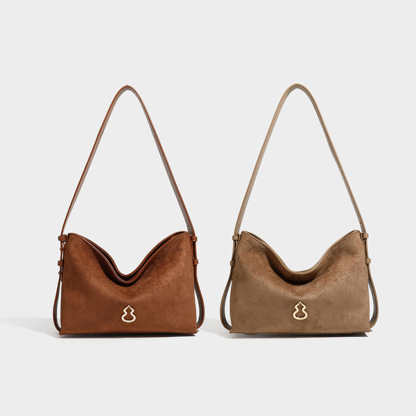 Slouchy suede-finish brown shoulder bag with long single strap and small gold-tone logo emblem on front, detail view 47