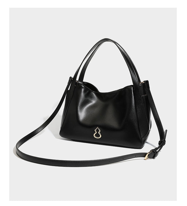 Structured glossy leather-look tote shoulder bag with dual top handles, detachable crossbody strap, side pockets, and, detail
