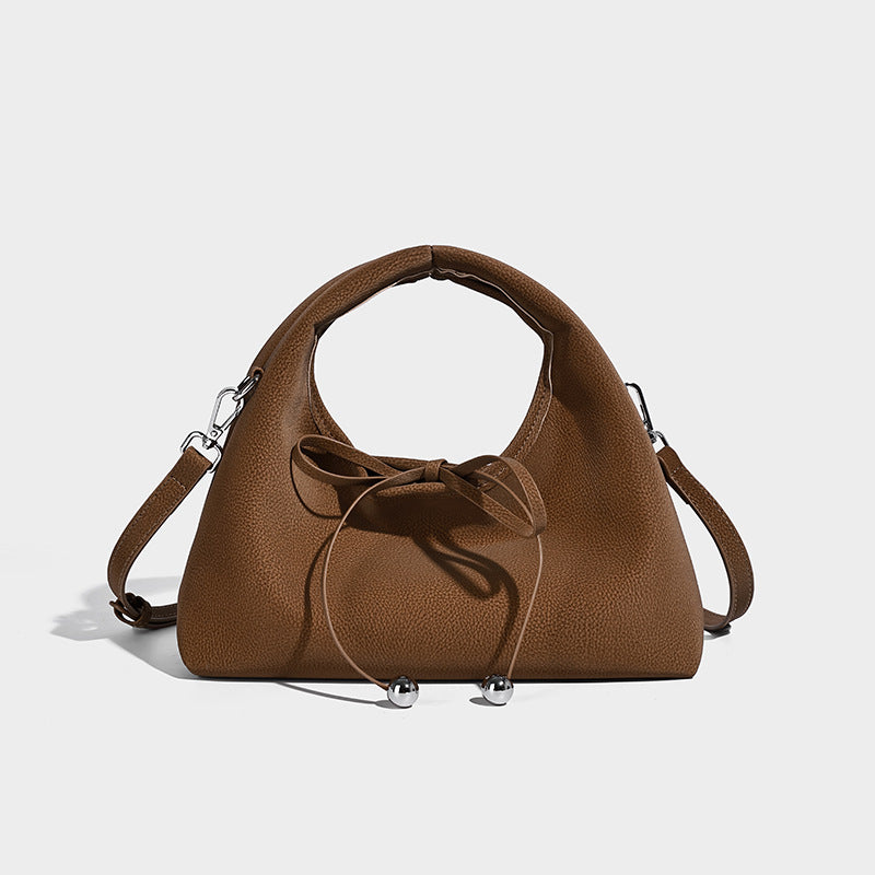 Pebbled matte trapezoid top-handle bag with drawstring bow closure, bead-tipped cords, silver-tone hardware, and detachable