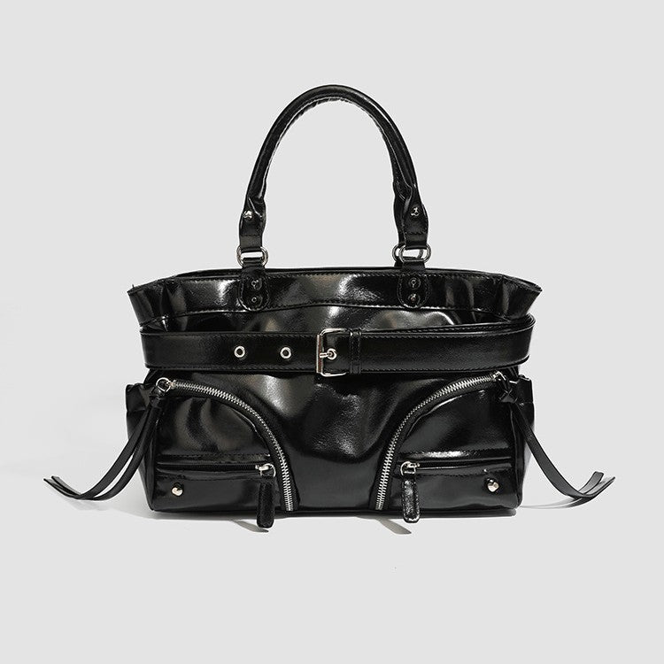 Black glossy structured tote bag with rivet and buckle detail, dual top handles, and detachable shoulder strap, detail view 3