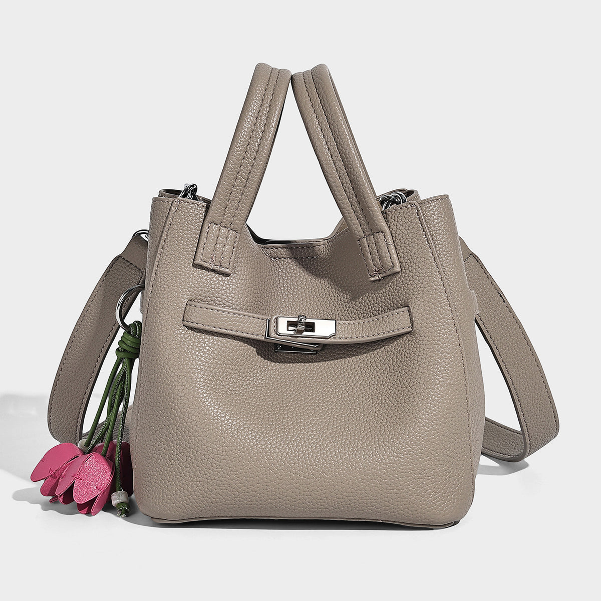Small structured pebbled bucket tote bag with dual top handles, silver turn-lock front pocket, and detachable shoulder strap