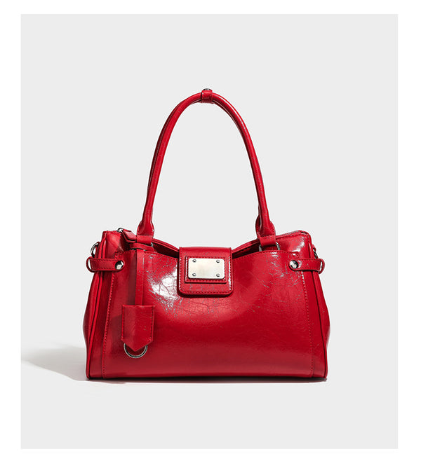 Structured glossy crinkled leather-look satchel with double top handles, front metal-plaque tab, silver-tone hardware, and