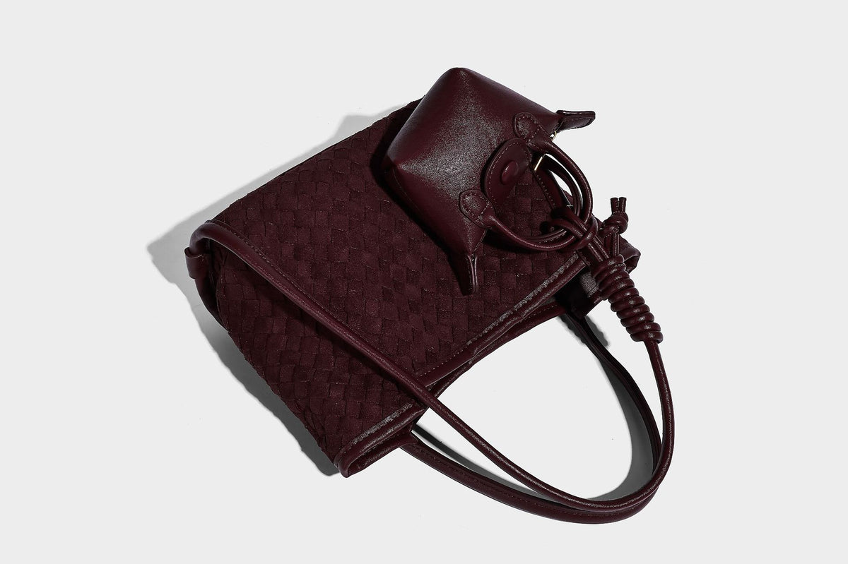 Strukturierte Tote-Bag mit gewebter Oberfläche, befestigtem Mini-Charm-Täschchen, geknoteten Tragegriffen und abnehmbarem Schulterriemen, Detailansicht