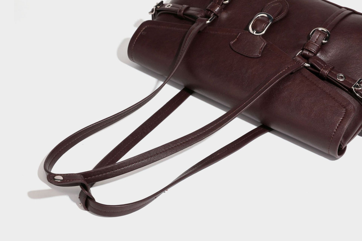 Strukturierte rechteckige Schultertasche mit Überschlagverschluss, vorderem Schnallengurt-Detail und ringförmigen Beschlägen in