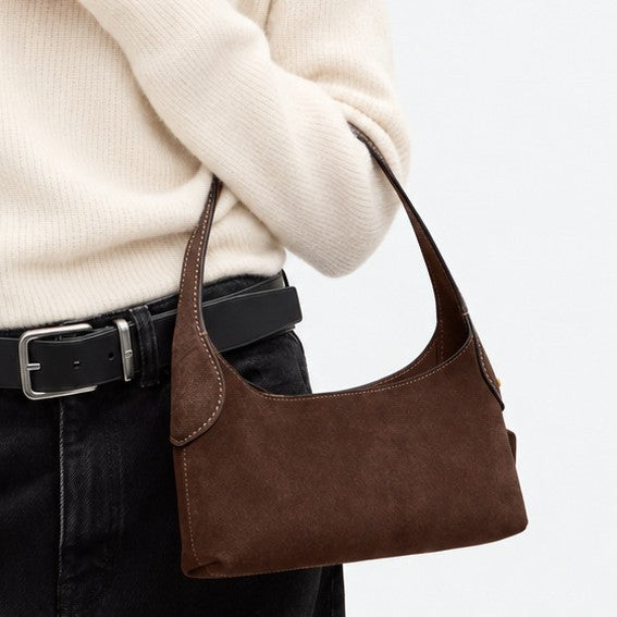 Slim crescent-silhouette shoulder bag in chocolate brown suede-look finish with contrast topstitching, top zip closure, thin