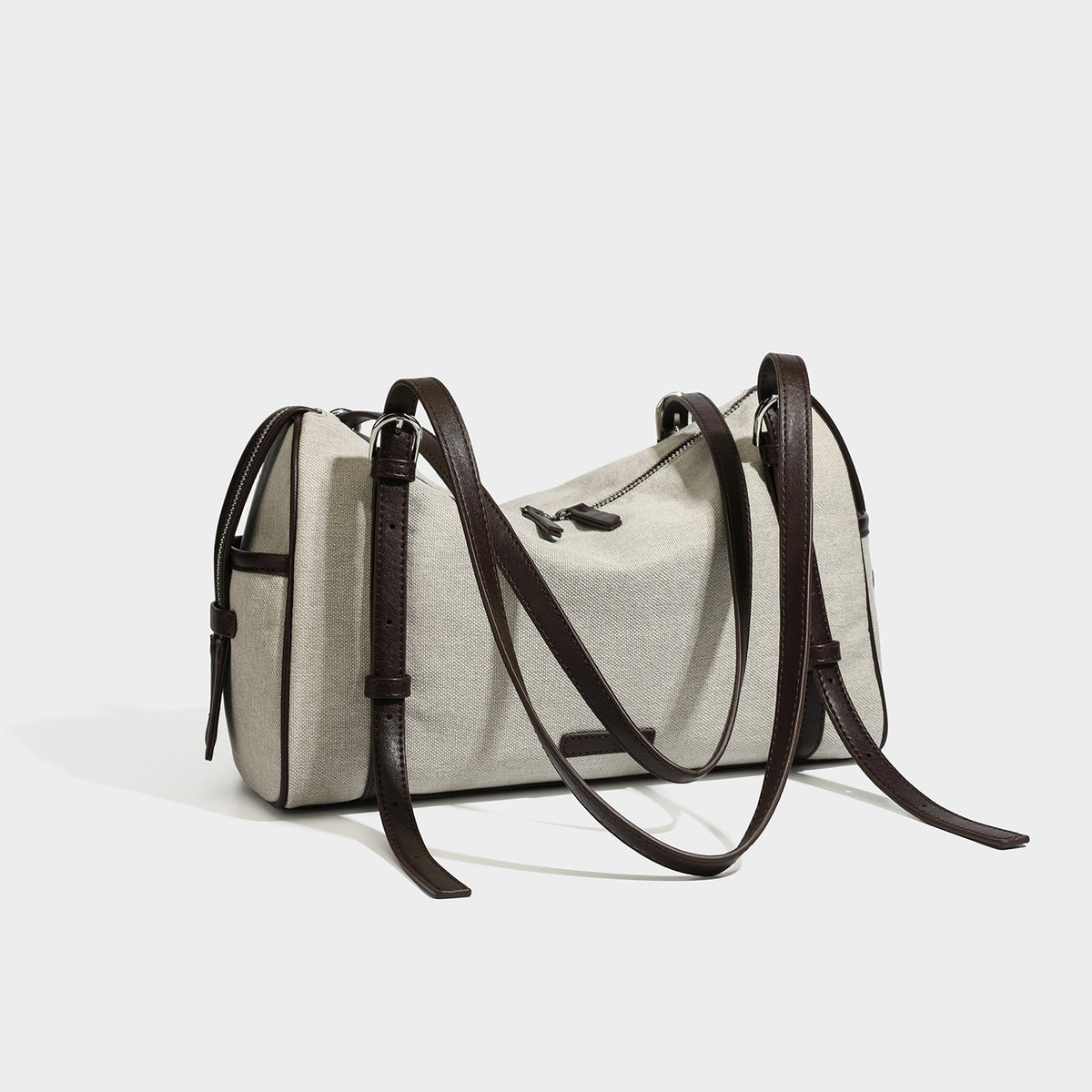 Cream canvas barrel shoulder bag with dark brown leather-look straps, trim, and silver-tone hardware, detail view 3