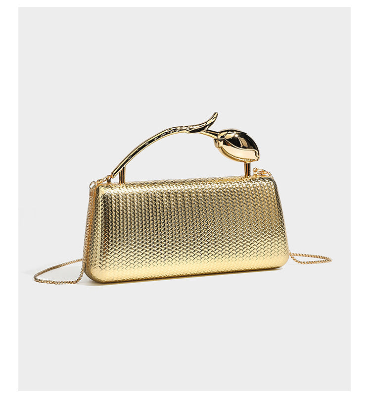 Structured rectangular metallic woven clutch bag with sculptural gold-tone leaf top handle and detachable chain strap, detail